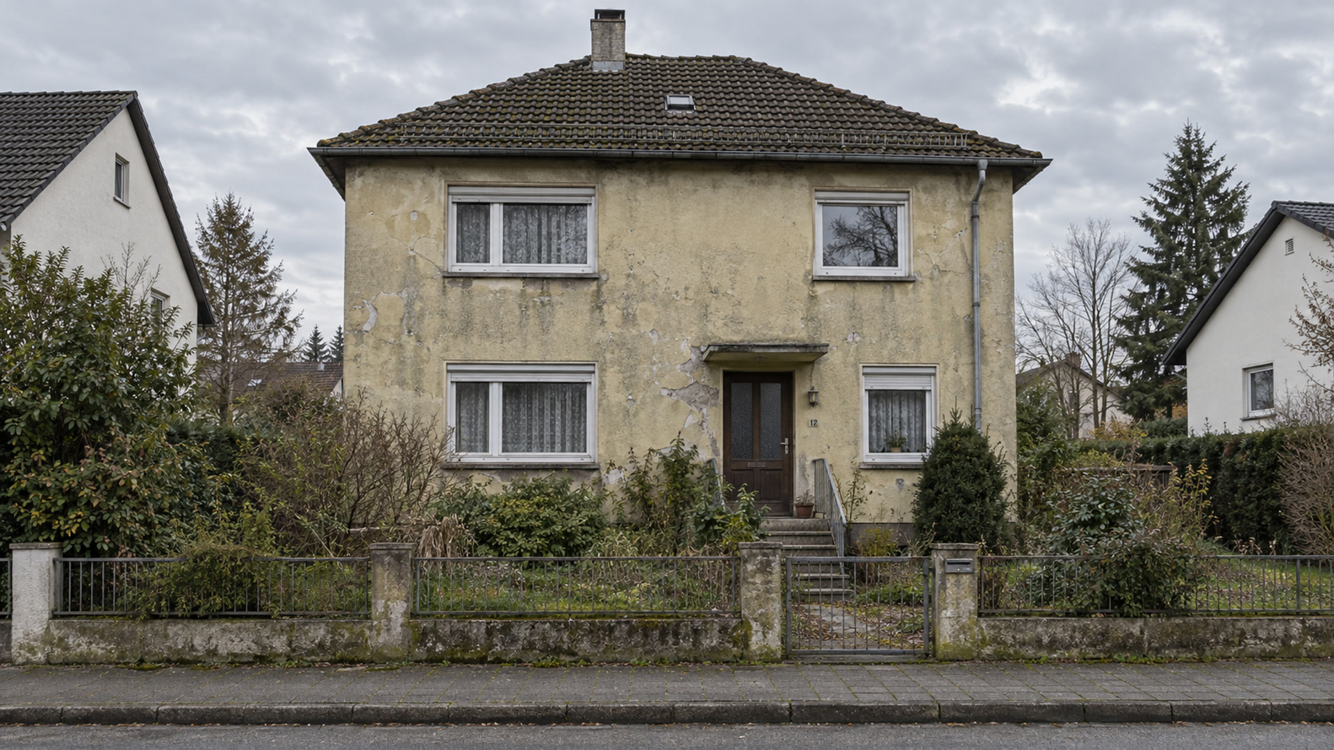 Älteres deutsches Einfamilienhaus mit verwitterter, rissiger Fassade (Beispielmotiv)
